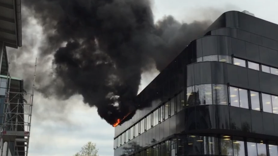 Svart rök och eldslågor från en byggnad