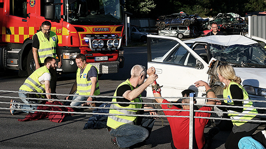 Civila insatspersoner hjälper en drabbad person på en olycksplats