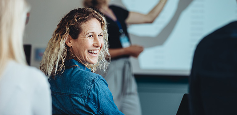 Kvinna som skrattar i en föreläsningssal