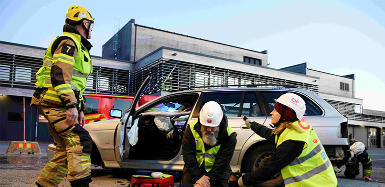 Tre Civila insatspersoner övar på räddning vid en iscensatt biloycka