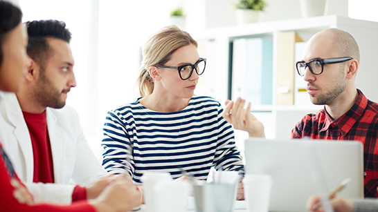 Fyra personer sitter ner och diskuterar