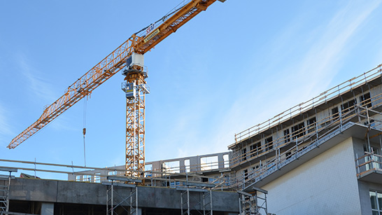 Huskant och lyftkran mot en blå himmel
