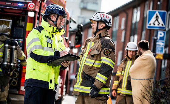 Restvärdeledare pratar med brandman vid olycksplats