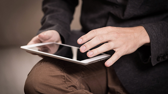 Någon sitter med en läsplatta i knät