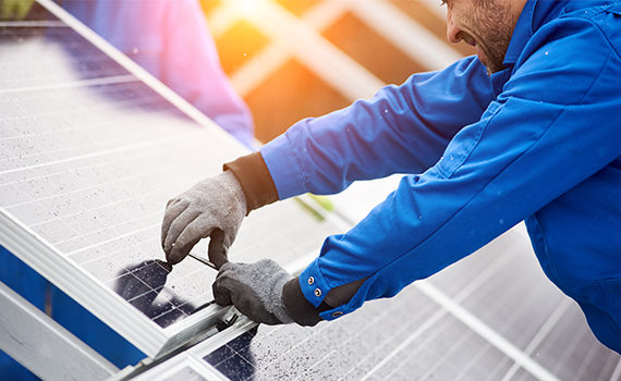 Solcellsinstallatör som arbetar med att installera solpaneler