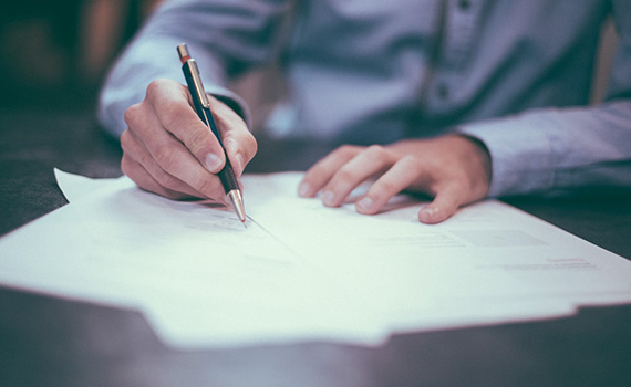 En man som skriver på ett papper