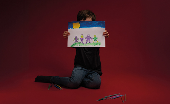 Ett barn visar upp en teckning