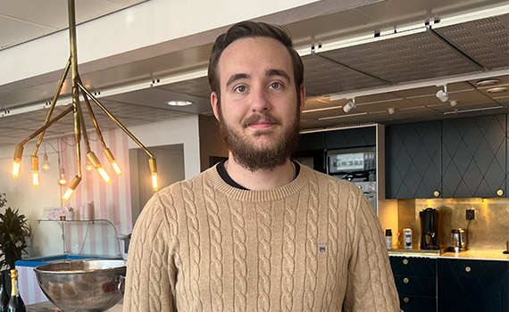 Linus som gått utbildningen Brandskyddsledare har en beige tröja tittar in i kameran