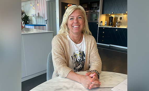 Michelle, tidigare deltagare på utbildningen Brandskyddsledare, sitter vid ett bord och ler in i kameran