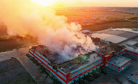 Rök kommer från taket på en brinnande anläggning