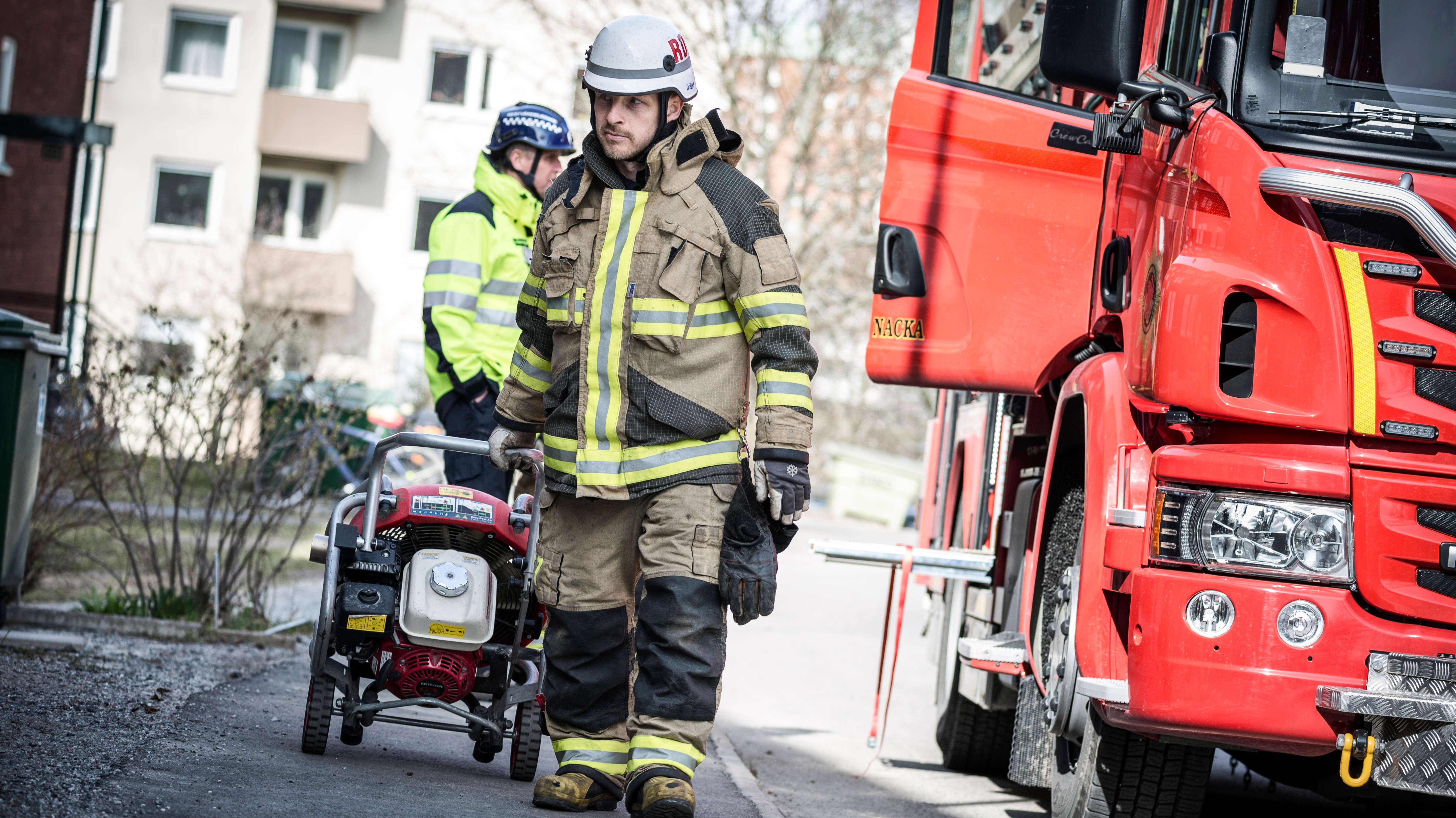 En person från Räddningtjänsten och en restvärdeledare intill en brandbil