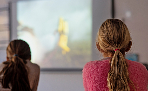 Elever ser på en filmduk i ett klassrum