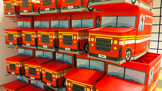 Flera röda leksaksbrandbilar staplade på varandra