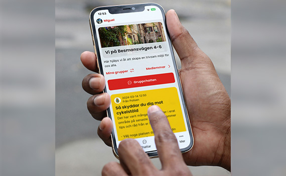 Hand håller mobil med Grannsamverkans app