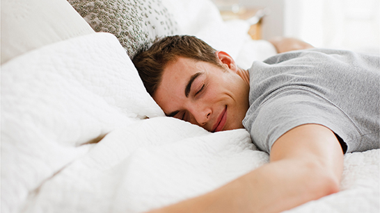 En man som sover på en säng