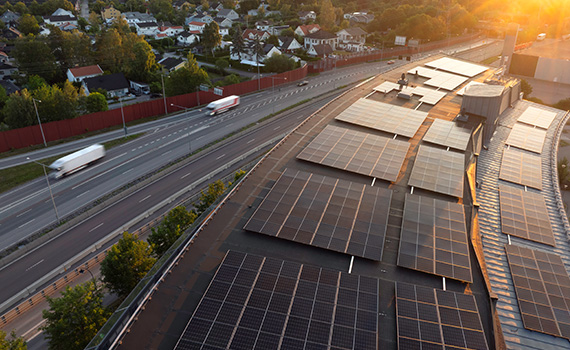 Solceller på ett hustak intill en väg och ett villakvarter
