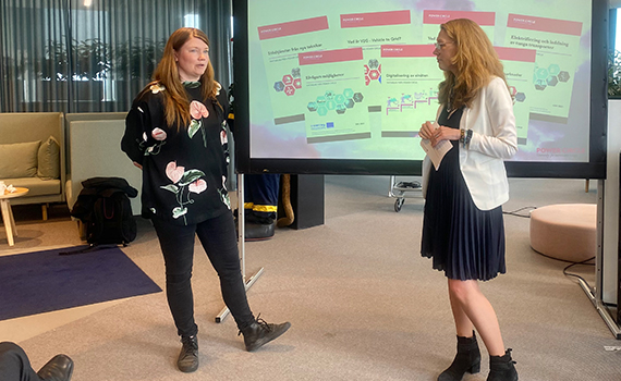 Johanna Lakso och Sofie Quant står framför en presentationsdduk och pratar