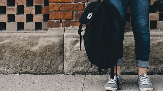 En skolelev håller i en ryggsäck