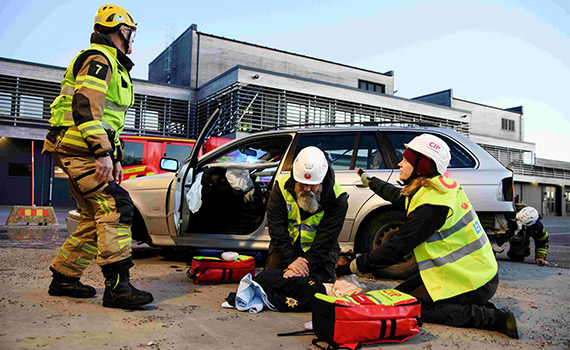 Tre Civila insatspersoner övar på räddning vid en iscensatt biloycka