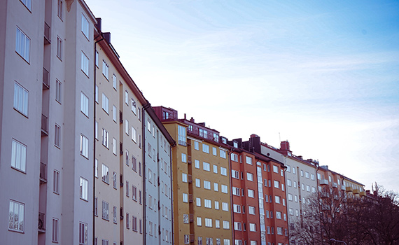 En länga med flerbostadshus med fasader i olika färger