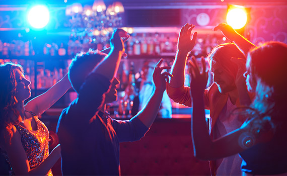 Personer dansar i en mörk lokal