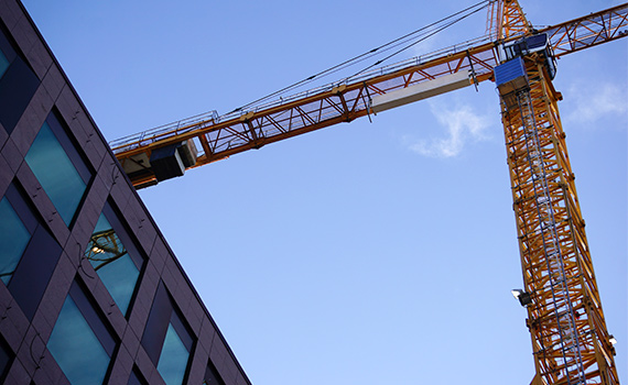 En byggkran och en modern byggnad sett underifrån