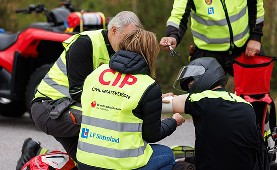 Civila insatspersoner hjälper person som ramlat av fyrhjuling