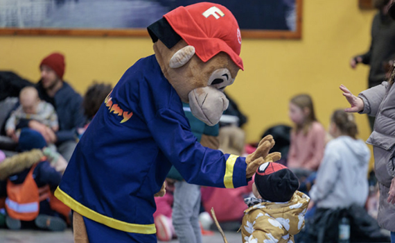 Apan Flammy gör high five med ett litet barn