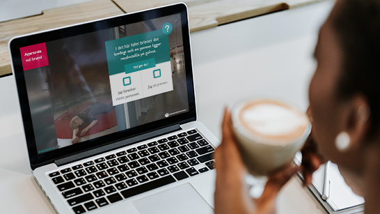 En person sitter med sin laptop och skärmen visar webbutbildningen