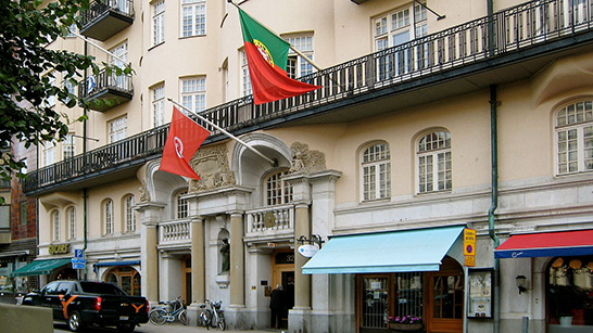 En husfasad med en röd flagga och en portugisisk flagga